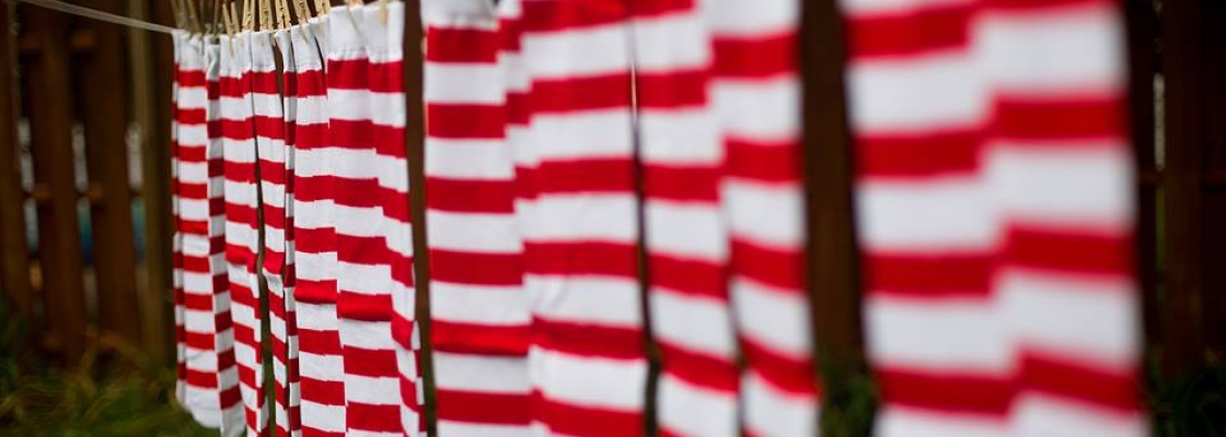 pairs of red and white striped socks hanging on a clothes line outside